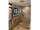 Modern bathroom featuring a glass-enclosed shower with natural stone tiles and contemporary fixtures at 833 Lantana Ave, Clearwater Beach, FL 33767