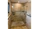 Modern bathroom featuring a glass-enclosed shower with natural stone tiles and contemporary fixtures at 833 Lantana Ave, Clearwater Beach, FL 33767