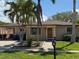 Charming single-story home with a manicured lawn, mature palms, and an inviting walkway to the front door at 833 Lantana Ave, Clearwater Beach, FL 33767