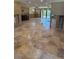 Spacious living room featuring natural stone flooring and bright, open space with glass doors to outdoors at 833 Lantana Ave, Clearwater Beach, FL 33767