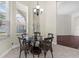 Bright dining area with trey ceiling, chandelier, and a round glass table near large windows at 8463 Dunham Station Dr, Tampa, FL 33647