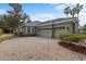 Spacious three-car garage with a brick paver driveway and well-maintained landscaping at 8463 Dunham Station Dr, Tampa, FL 33647