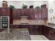 The spacious kitchen features dark wood cabinetry, granite countertops, and stainless steel appliances at 8463 Dunham Station Dr, Tampa, FL 33647
