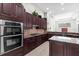 Gourmet kitchen featuring dark cabinets, stainless steel appliances, granite countertops, and a kitchen island at 8463 Dunham Station Dr, Tampa, FL 33647