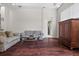 Comfortable living room with hardwood floors, a large window, and a view of the hall bathroom at 8463 Dunham Station Dr, Tampa, FL 33647
