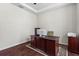 Stylish office featuring wood floors, tray ceiling, and a dark wood desk facing the center of the room at 8463 Dunham Station Dr, Tampa, FL 33647