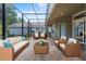 Inviting screened patio featuring brick flooring and comfortable seating arrangement at 8463 Dunham Station Dr, Tampa, FL 33647