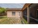Exterior view showcases a screened-in porch off the back of the home and access to the yard at 9327 Pontiac Dr, Tampa, FL 33626