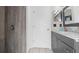 This bathroom features tile wall, a gray vanity with marble countertop and a door with mirror at 9327 Pontiac Dr, Tampa, FL 33626