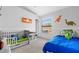 This bedroom features two beds with blue and green bedding, a window and toy storage at 9327 Pontiac Dr, Tampa, FL 33626
