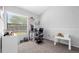 This office space features a window, gray carpet, a white and black desk and rolling chairs at 9327 Pontiac Dr, Tampa, FL 33626