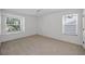 Bright, carpeted bedroom with two windows and white walls, creating a clean and open feel at 962 Marco Ne Dr, St Petersburg, FL 33702