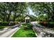 Gated entrance to the community with well-manicured landscaping and mature trees at 962 Marco Ne Dr, St Petersburg, FL 33702