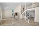 Bright and airy living area with staircase, large windows, and tile flooring at 962 Marco Ne Dr, St Petersburg, FL 33702