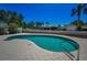 A kidney-shaped pool with a paved deck and a view of the backyard landscape under a bright blue sky at 962 Marco Ne Dr, St Petersburg, FL 33702