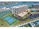 Exterior view of the waterfront condominium complex with tennis court, boat slips, and swimming pool at 1 Key Capri # 211W, Treasure Island, FL 33706