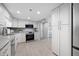 Well-lit kitchen with stainless appliances, granite counters, modern cabinets, and wood-look flooring at 1 Key Capri # 211W, Treasure Island, FL 33706