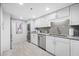 Bright kitchen featuring stainless steel appliances, white cabinetry, granite countertops, and in-unit laundry at 1 Key Capri # 211W, Treasure Island, FL 33706