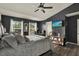 Bedroom with dark accent wall, mounted TV, and wood-look flooring at 11041 Black Swan Ct, Seffner, FL 33584