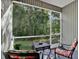 Screened porch with colorful outdoor furniture overlooking private back yard at 11041 Black Swan Ct, Seffner, FL 33584