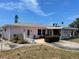 Side view of a home with an anchor detail, patio, and mature landscaping at 11365 4Th E St, Treasure Island, FL 33706