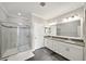 Well-lit bathroom with double sink vanity, tiled floors, and glass shower door, creating a fresh space at 11548 Crowned Sparrow Ln, Tampa, FL 33626