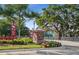 A welcoming West Lake entrance with manicured landscaping, mature trees, and visible community homes at 11548 Crowned Sparrow Ln, Tampa, FL 33626