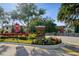West Lake community entrance featuring brick signage, colorful flowers, and well-maintained landscaping at 11548 Crowned Sparrow Ln, Tampa, FL 33626