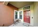 Charming front porch with a red door, small table, and two chairs for relaxing outdoors at 11548 Crowned Sparrow Ln, Tampa, FL 33626