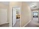 Hallway with neutral paint leading to a home office and bathroom with carpet flooring at 11548 Crowned Sparrow Ln, Tampa, FL 33626