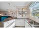 Well-equipped kitchen with white cabinets, subway tile backsplash, and modern fixtures with view to living space at 11548 Crowned Sparrow Ln, Tampa, FL 33626