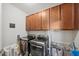 Well-equipped laundry room with updated machines, overhead cabinets, and laundry supplies at 11548 Crowned Sparrow Ln, Tampa, FL 33626
