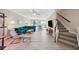 Open-concept living room featuring wood-look tile floors and a staircase at 11548 Crowned Sparrow Ln, Tampa, FL 33626