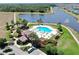 Aerial view of the resort-style community pool with lounge chairs, landscaping, and a lake at 11625 Tetrafin Dr, Riverview, FL 33579