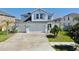 Charming two-story home featuring a three-car garage, landscaped yard, and crisp white exterior at 11625 Tetrafin Dr, Riverview, FL 33579