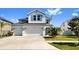 Charming two-story home featuring a three-car garage, landscaped yard, and crisp white exterior at 11625 Tetrafin Dr, Riverview, FL 33579