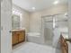 Bathroom with tiled floor, separate shower and tub, double vanity, and wood cabinets at 11716 Summer Springs Dr, Riverview, FL 33579