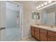 Bathroom featuring dual sinks, a large mirror, a neutral color palette, and tile flooring at 11716 Summer Springs Dr, Riverview, FL 33579