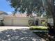 Charming single-story home featuring a three-car garage, manicured lawn, and beautiful landscaping at 11716 Summer Springs Dr, Riverview, FL 33579