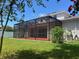 Backyard exterior featuring a screened-in lanai and a lush green lawn at 11716 Summer Springs Dr, Riverview, FL 33579