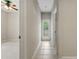 Hallway featuring tile flooring, doorway to back patio, and entrance to the bedroom at 11716 Summer Springs Dr, Riverview, FL 33579