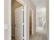 Hallway featuring an open door to a walk-in closet and access to a bathroom with glass enclosed shower at 11716 Summer Springs Dr, Riverview, FL 33579