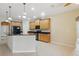 Well-lit kitchen with wood cabinetry, dark countertops, island, and black appliances at 11716 Summer Springs Dr, Riverview, FL 33579