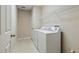 Convenient laundry room with a washer, dryer, storage shelving, and tiled flooring at 11716 Summer Springs Dr, Riverview, FL 33579