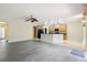 Spacious living area with gray wood floors, an open kitchen, and natural light at 11716 Summer Springs Dr, Riverview, FL 33579