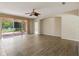 Open living room features wood-look tile floors, a ceiling fan, and sliding glass doors to the lanai at 11716 Summer Springs Dr, Riverview, FL 33579