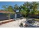 Landscaped backyard with a stone patio, a dining table, and a detached garage at 121 W Mohawk Ave, Tampa, FL 33604