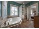 Bright bathroom featuring a soaking tub, glass block shower, and access to the main bedroom at 121 W Mohawk Ave, Tampa, FL 33604
