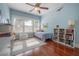 Bright bedroom featuring cheerful blue walls, ceiling fan and hardwood floors at 121 W Mohawk Ave, Tampa, FL 33604