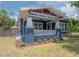 Charming craftsman-style home boasts blue siding, white trim, a welcoming front porch, and fresh landscaping at 121 W Mohawk Ave, Tampa, FL 33604